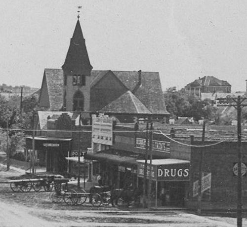 Milford Texas corner drug store and church, early 1900s