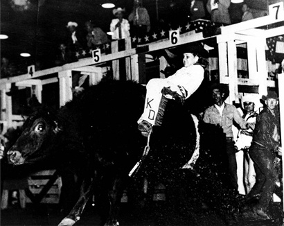 Kathy Dell  riding bull at rodeo