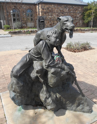 Old Yeller bronze sculpture by Garland Weeks in front of Mason County Library
